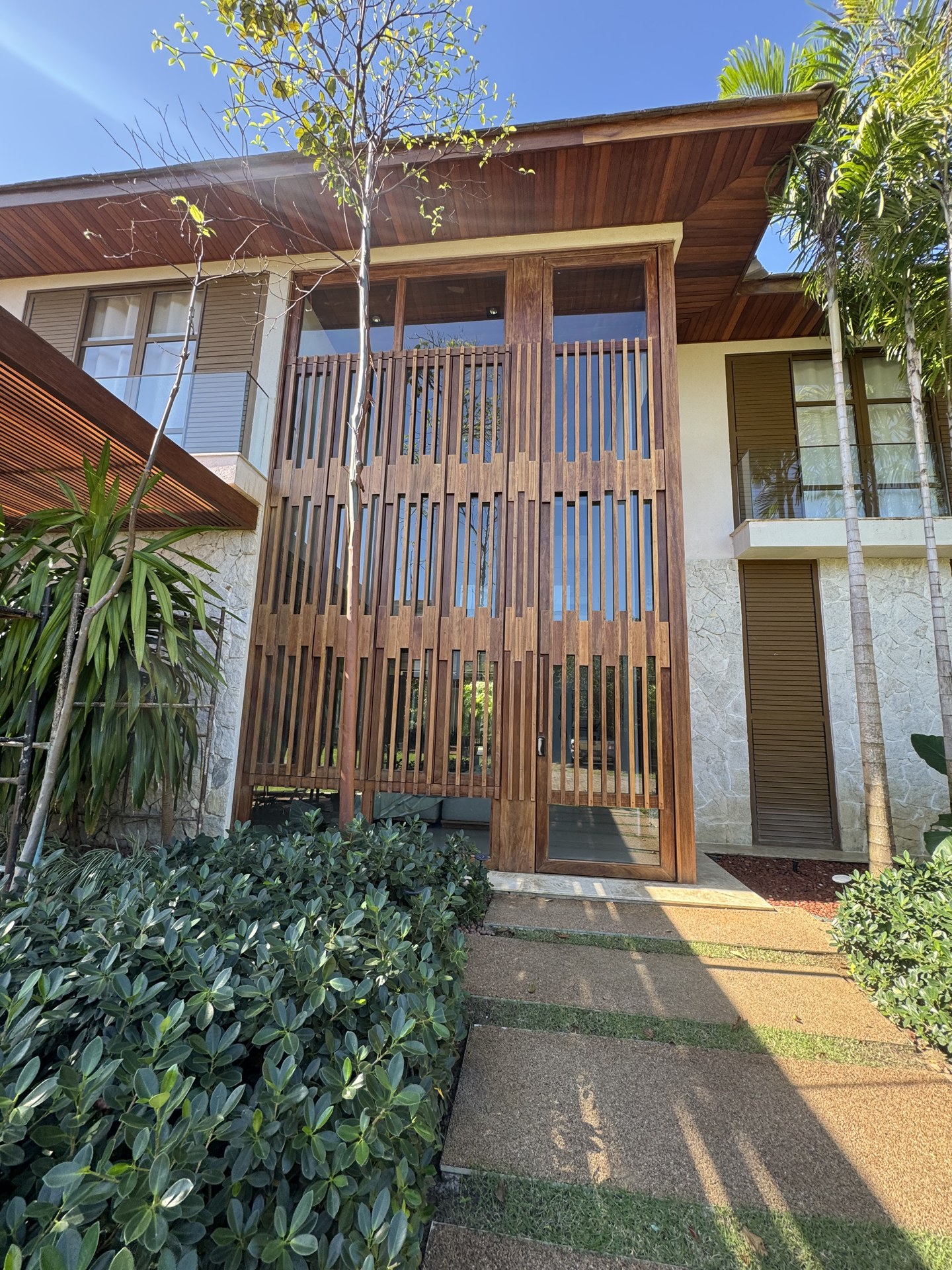 Fachada residencial com painéis e esquadrias em madeira