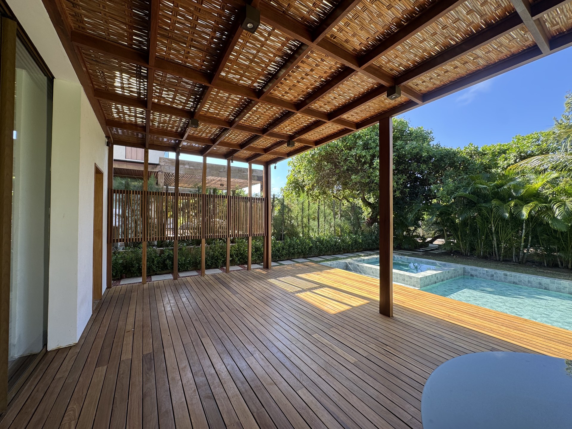 Deck e pergolado em madeira na área externa de uma residência